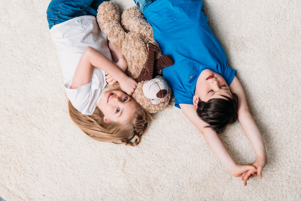 little boy and girl lying on carpet - Foto, Imagem