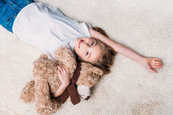 niña acostada en la alfombra en casa
 - Foto, Imagen