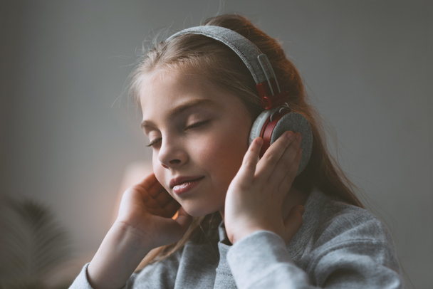 niña escuchando música en auriculares
 - Foto, Imagen