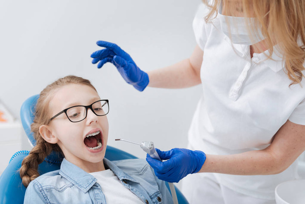 Professional trained dentist applying new dental tools - Фото, изображение