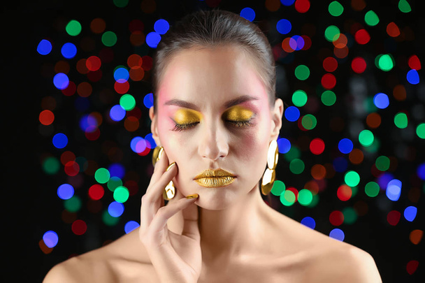 Beautiful woman with holiday makeup against defocused lights - Photo, Image