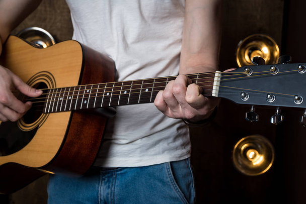 Gitarre spielen. akustische Gitarre in den Händen des Gitarristen. horizontaler Rahmen - Foto, Bild