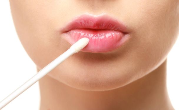 Beautiful young woman applying lipstick - Foto, imagen