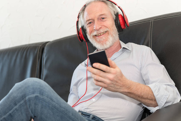 Modern mature man listening music on mobile phone - Foto, Imagem