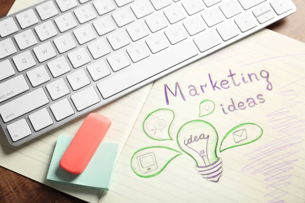 Text MARKETING IDEAS and drawing of light bulb in notebook - 写真・画像