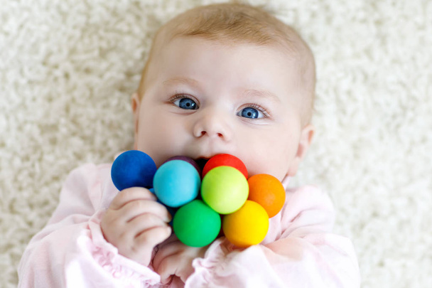 Roztomilá holčička hrát s hračkami, barevné dřevěné chrastítko - Fotografie, Obrázek
