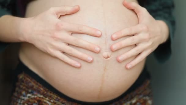 Terhes nő fogdossa a hasát - Felvétel, videó