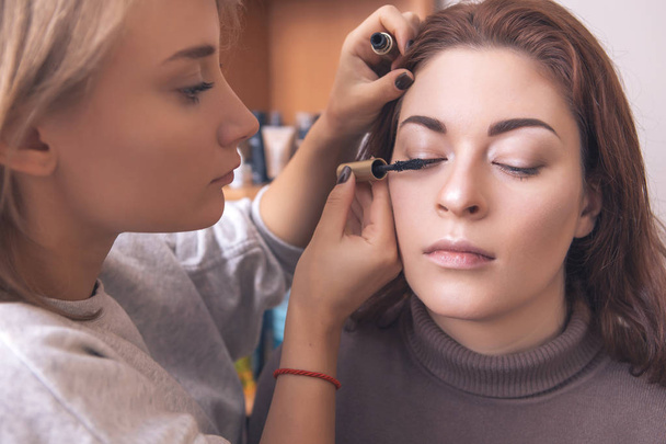 Profesionální make-up umělce použít řasenku na mladý bělošský w - Fotografie, Obrázek