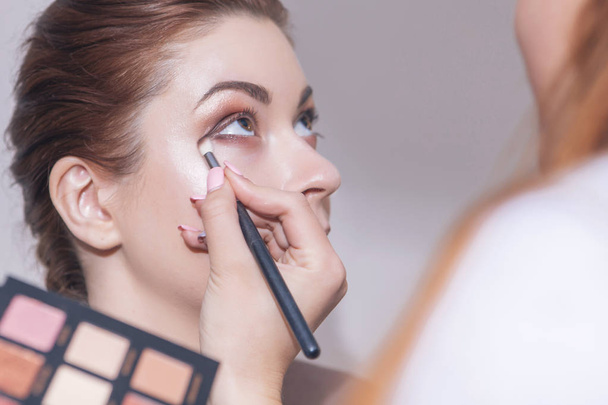 Maquiagem profissional artista aplicar rímel para um jovem caucasiano w
 - Foto, Imagem