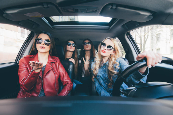 Grupa przyjaciół, zabawy zaostrzy prowadzenia samochodu. Śpiew i śmiejąc się na drodze - Zdjęcie, obraz