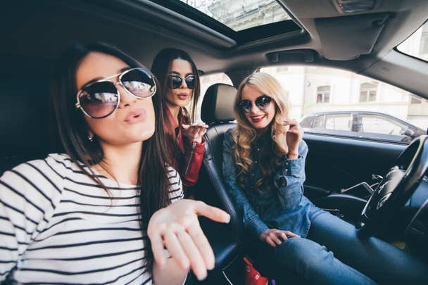 Ryhmä tyttöjä hauskaa autossa ja ottaa selfietä kameran kanssa road trip
 - Valokuva, kuva