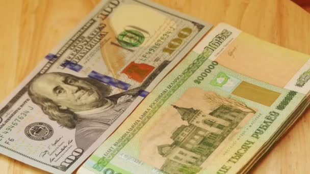 Fehérorosz rubel par érték kétszázezer hazugság és amerikai dollár (amerikai dollár) a fából készült asztal. - Felvétel, videó