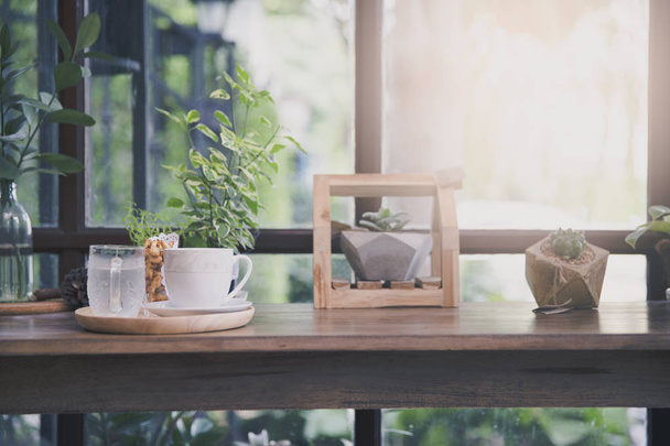 Kuppi kuumaa kahvia ympyrässä puinen tarjotin puinen laskuri kahvilassa
 - Valokuva, kuva