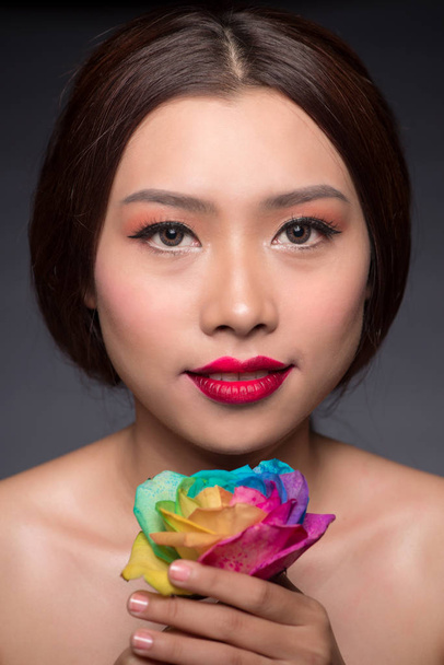 woman holding colorful rose - 写真・画像