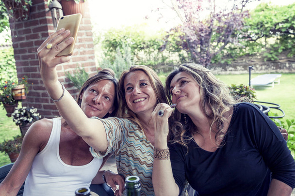 three pretty mature women take a selfie in the countryside - Fotoğraf, Görsel