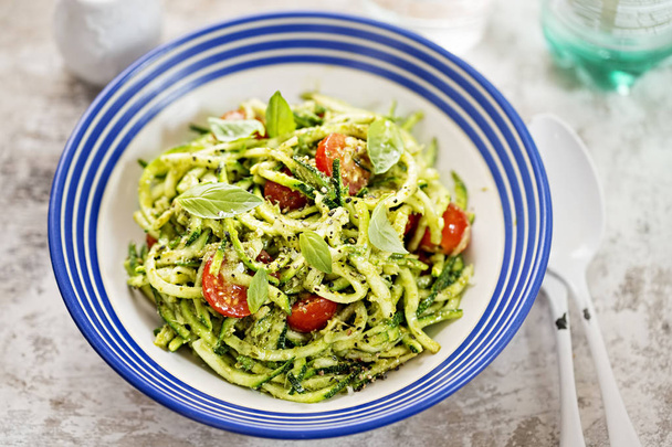 Spiralled courgette spaghetti with green pesto and cherry tomatoes  - 写真・画像