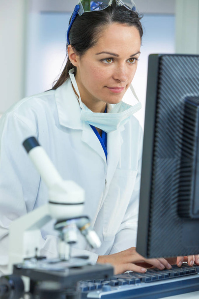 θηλυκός επιστήμονας ή ο γιατρός που χρησιμοποιούν τον υπολογιστή στο εργαστήριο - Φωτογραφία, εικόνα