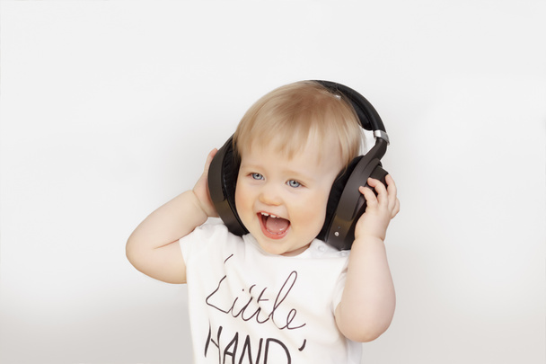 Little girl listening to music on headphones - Fotografie, Obrázek