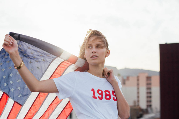 Blonde female model holds up american flag - Foto, Bild