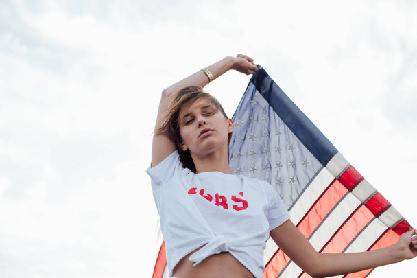 Blonde female model holds up american flag - Foto, immagini