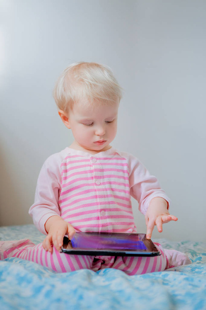 blond baby girl with tablet - Fotó, kép