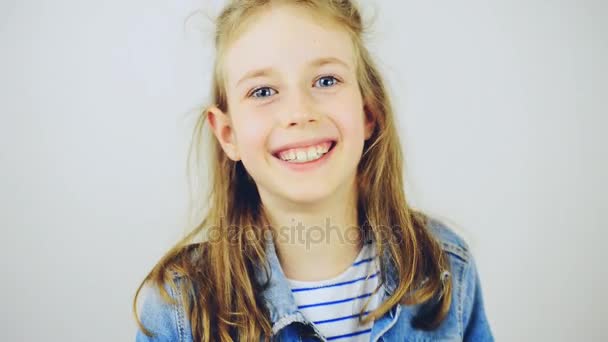 Onnellinen pieni tyttö hymyilee kameralle
. - Materiaali, video
