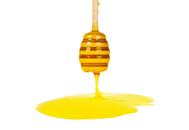 Honey dripping isolated on a white background - Fotoğraf, Görsel
