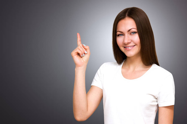 Beautiful young Caucasian woman smiling with space for copy. shows thumb up - Фото, изображение