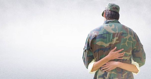 Back of soldier hugging against white wall - Valokuva, kuva
