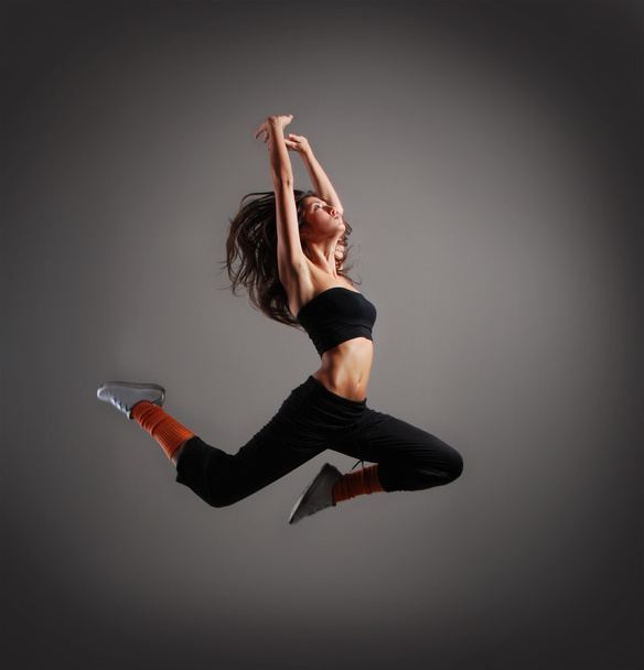 Young and sexy modern dancer over grey background - Fotoğraf, Görsel