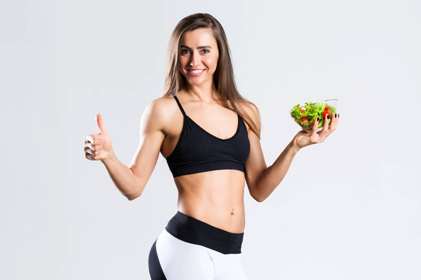 Щаслива спортивна жінка з салатом Ізольовані
. - Фото, зображення