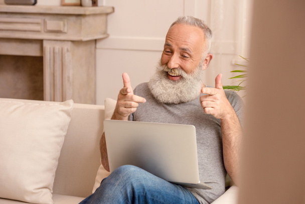 Senior man met laptop - Foto, afbeelding