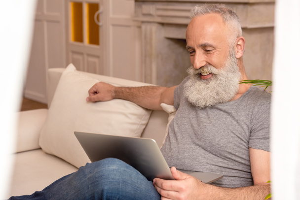 Senior man met laptop - Foto, afbeelding