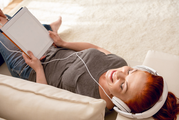 Žena poslouchající hudbu ve sluchátkách - Fotografie, Obrázek
