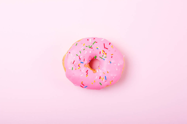 Pink round donut on pastele background. Flat lay, top view. - Foto, imagen