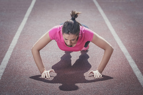 Athletic woman working out on track  - Valokuva, kuva