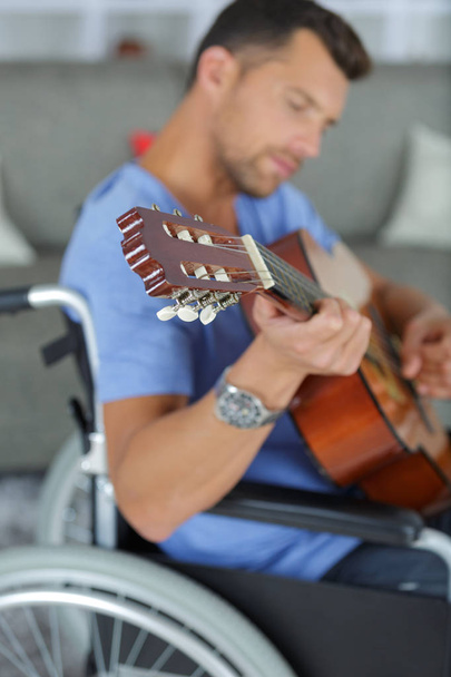 man in the wheelchair playing guitar - Fotó, kép