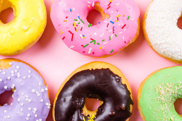 Colorful round donuts on pink background. Flat lay, top view. - 写真・画像