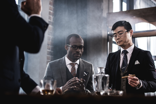 équipe d'affaires multiculturelle passer du temps, fumer des cigares et boire du whisky
 - Photo, image