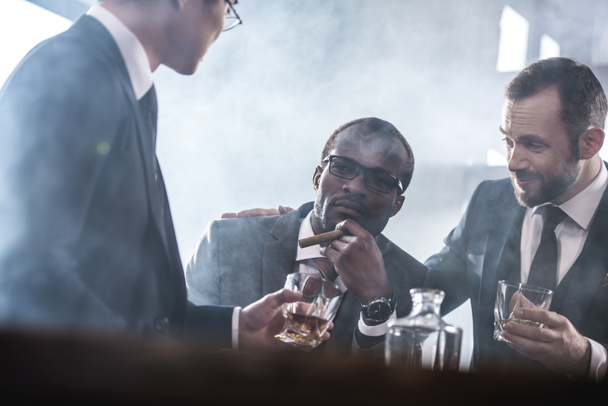 Multiethnic group of businessmen spending time together drinking whiskey and smoking, multicultural business team - Valokuva, kuva
