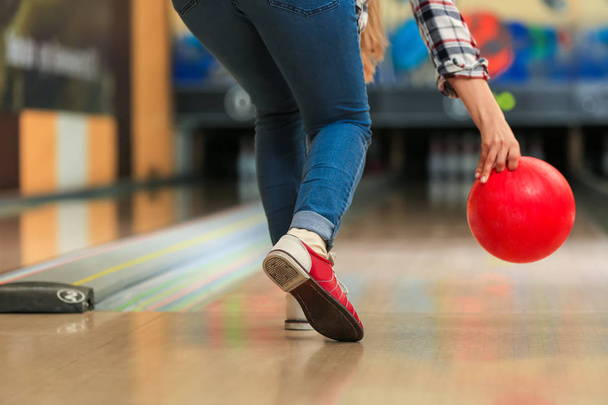 Young woman throwing ball in bowling club - Foto, imagen
