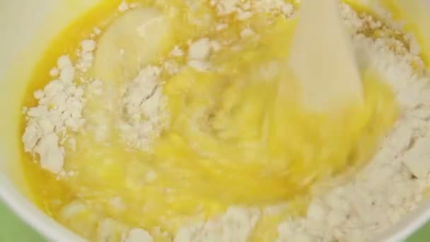 Close up of mixing eggs, melted butter and milk into a nice smooth cake mix. - Séquence, vidéo