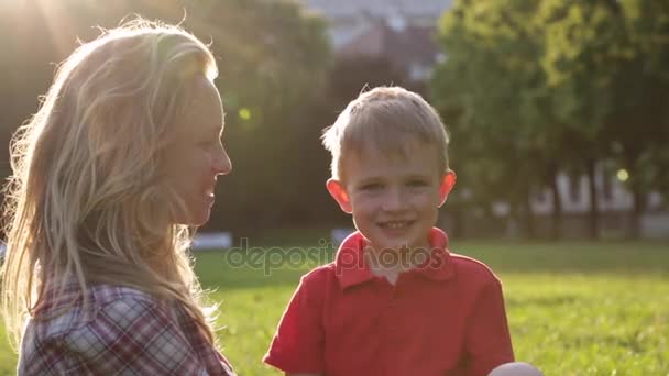 Grappige grapje kind en moeder weergeven tong in het park - Video