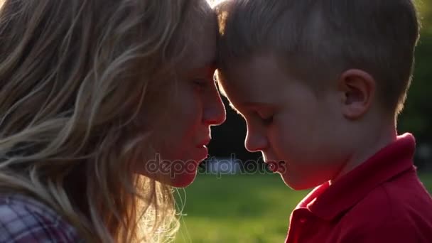 Feliz besar a mamá y al niño al atardecer
 - Imágenes, Vídeo