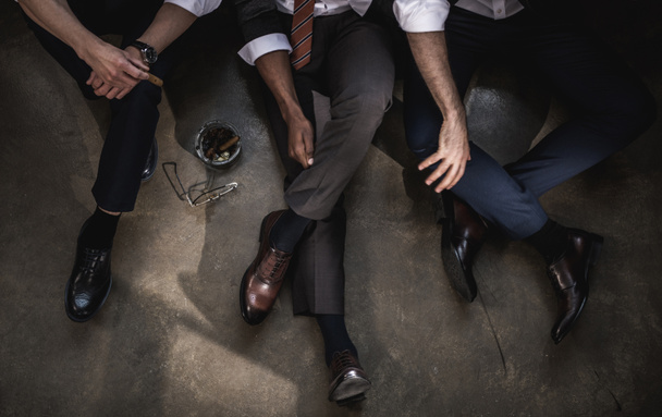 Cropped shot of group of businessmen sitting on floor together - Photo, Image