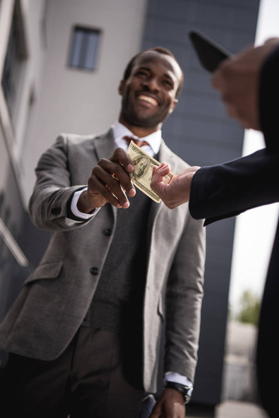 jovem africano americano empresário em formalwear levando dinheiro ao ar livre
 - Foto, Imagem