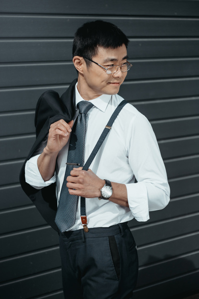 confiant élégant asiatique homme d'affaires posant à l'extérieur au mur
 - Photo, image