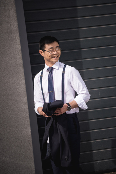 joven elegante asiático hombre de negocios en gafas de pie al aire libre
 - Foto, Imagen