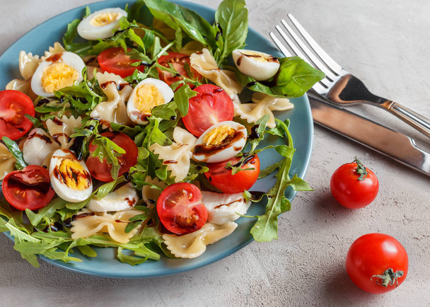 Ensalada de pasta con huevos de codorniz, tomates, rúcula, mozzarella y albahaca
 - Foto, Imagen