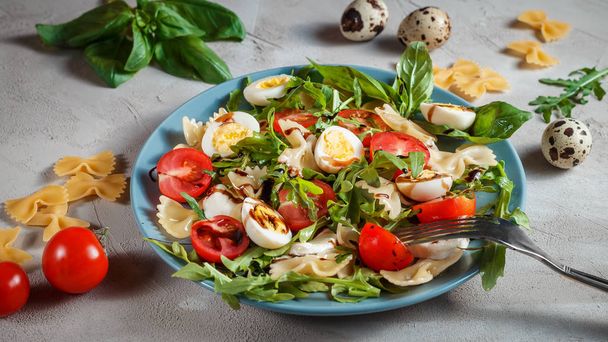 Pasta salaatti viiriäisen munia, tomaatteja, rucola, mozzarella ja basilika
 - Valokuva, kuva